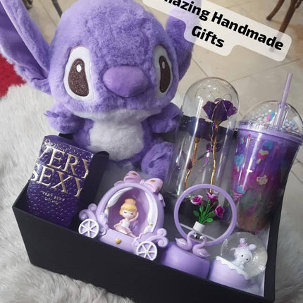 بوكس ملكة البنفسجي الساحرة - صندوق أسود فاخر مع فراشات ذهبية براقة يحتوي على Stitch البنفسجي الساحر الجميل جداً مع شرابة بنفسجية براقة، عطور فاخرة ملكية بعبوات بنفسجية شفافة براقة بألوان متعددة، كؤوس شفافة ملونة بنفسجية وملونة جميلة بداخلها أشكال براقة، عطر برائحة ملكية ناعمة، مستحضرات عناية بالبشرة بألوان بنفسجية فاخرة، مكياج متكامل احترافي، ورود بيضاء ناعمة، حلويات فاخرة ملفوفة بأشرطة ملونة، تقويم جميل "Amazing Handmade Gifts"، كل شيء منسق بشكل فني دقيق ملكي جداً - هدية ملكية بنفسجية ساحرة من كنوز مصر
