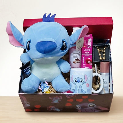بوكس ستيتش عشق الزرقاء - دمية Stitch بعينيها الكبيرة الحمراء مع كوب قهوة Stitch بتصميم جميل، قلادة Stitch ذهبية فاخرة، مجوهرات صغيرة أنيقة، خلفية متدرجة من الأرجواني إلى الأزرق جميلة جداً - تصوير احترافي - هدية حب فاخرة من كنوز مصر
