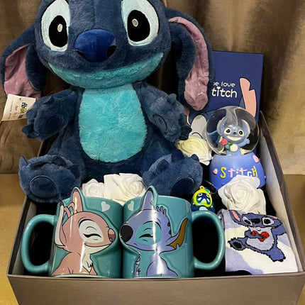 بوكس ستيتش السعادة الثالثة - دمية Stitch بعينين زرقاء سماوية كبيرة وجميلة جداً مع كوب شفاف فاخر بتصميم Stitch، ورود بيضاء ديكورية رومانسية فاخرة، بطاقة تهنئة We Love Stitch جميلة، كتب Stitch، جوارب ملونة وناعمة، مستحضرات عناية، صندوق فاخر - خلفية بنية هادئة - هدية حب رومانسية فاخرة من كنوز مصر
