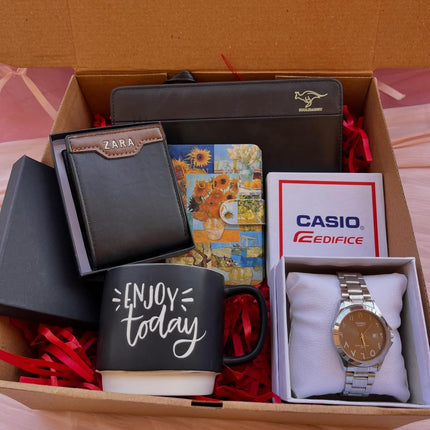 صندوق كرتون بني فاخر يحتوي على ساعة Casio Edifice مميزة، كوب قهوة أبيض مكتوب عليه "Coffee is always a good idea"، محفظة جلدية سوداء، وزهور جافة معطرة بيضاء.