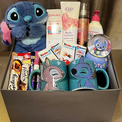 بوكس ستيتش حلم الزرقاء الثاني - دمية Stitch أزرق غامق جميلة مع كوب شفاف فاخر بتصميم Stitch، ورود بيضاء ديكورية رومانسية، بطاقة تهنئة We Love Stitch، جوارب ملونة، مستحضرات عناية، صندوق فاخر - خلفية بنية هادئة - هدية حب رومانسية فاخرة من كنوز مصر

